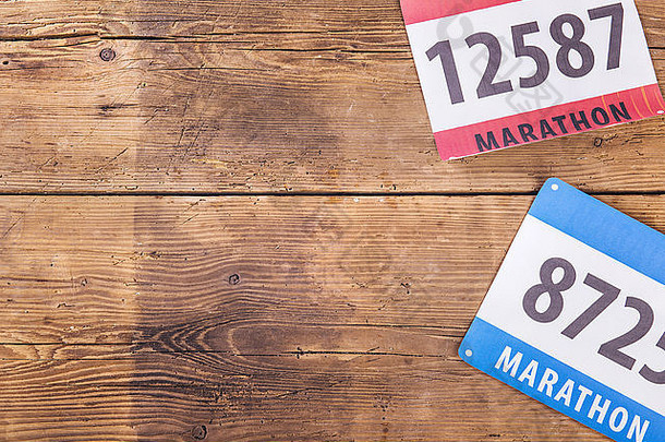 两个马拉松比赛号码放在木地板背景上