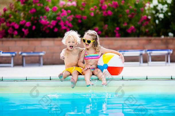 孩子们在室外游泳池玩耍。小女孩和小男孩在热带海滩岛的度假泳池里玩耍和游泳。游泳和眼睛