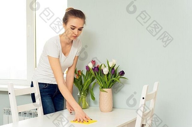 家庭主妇在擦桌子上的灰尘。妇女用布把日常家务抹去灰尘。家务和家务。春季<strong>大扫除</strong>。