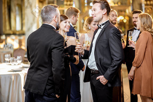 一群穿着复古风格的优雅人士聚在一起，在盛大庆典期间在豪华餐厅畅饮
