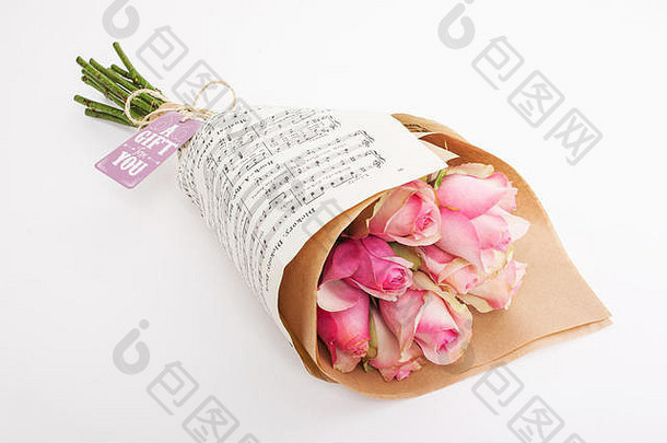 一束粉红色玫瑰，用音乐纸包裹，配礼品卡和领带