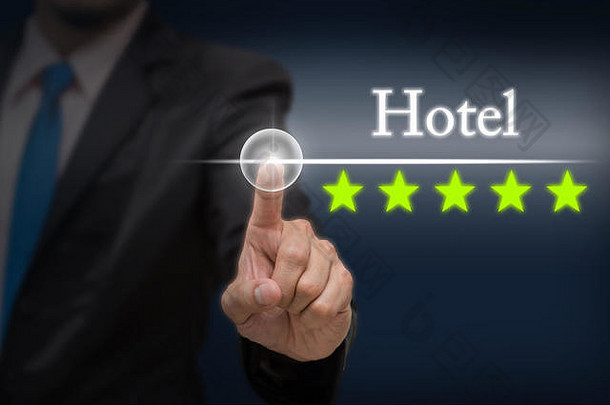 商人点着五星按钮，在深蓝调的背景下提高酒店的评级，商业评估理念，提高评级