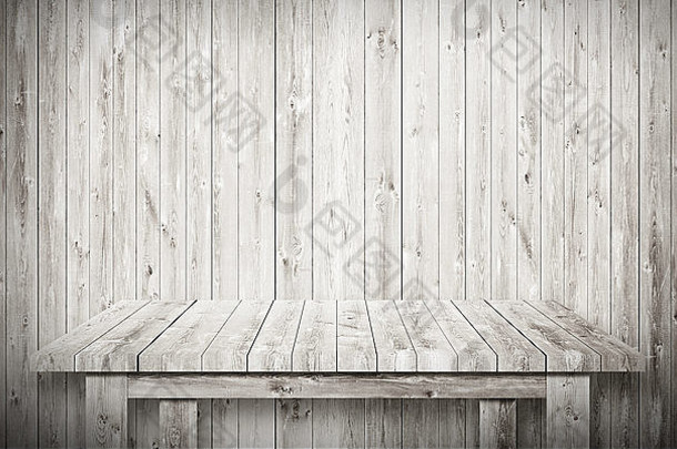 木墙旁的灰色空桌子