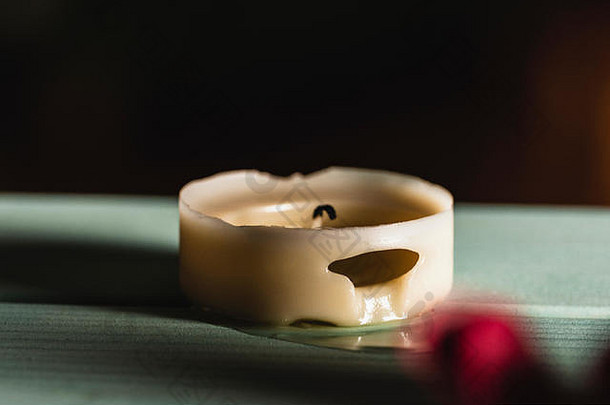 木制桌子上熔化的蜡烛和黑色背景