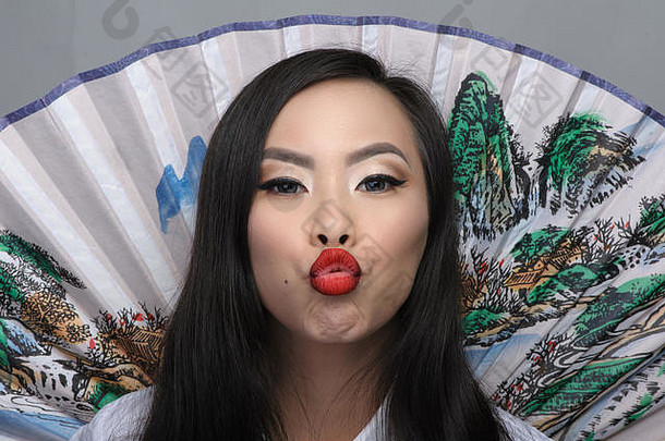 肖像美丽的年轻的亚洲女人风扇背景