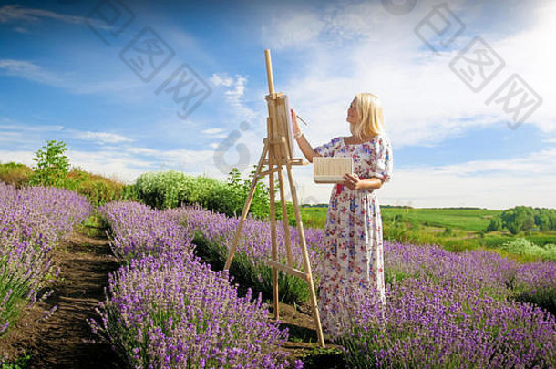 快乐微笑的女人在早晨画薰衣草田