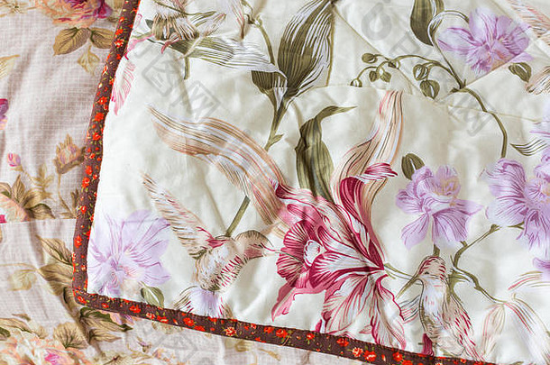 手工、拼布、绗缝、缝纫、家居舒适概念-一条浅柠檬色的地毯，带有虹膜印花和红色胶带，另一条覆盖粉色地毯和玫瑰