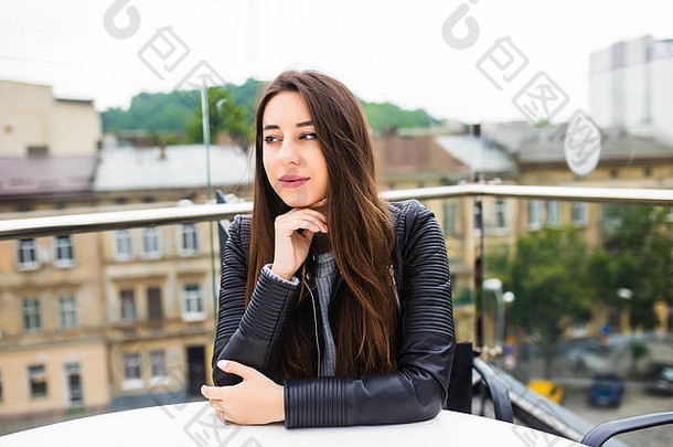 美丽的年轻女子独自坐在阳台上的<strong>咖啡</strong>馆里等待点菜。在<strong>咖啡</strong>馆喝<strong>咖啡</strong>的漂亮年轻女子