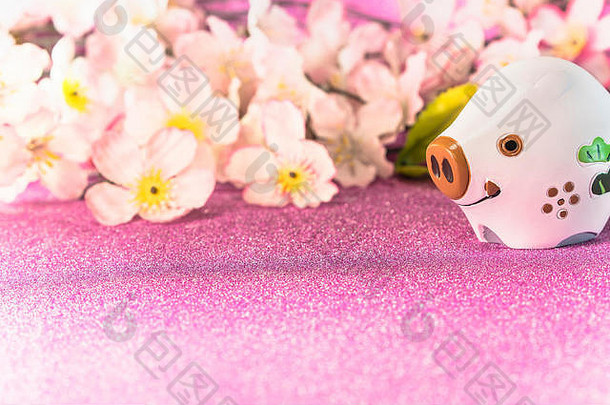 粉色闪烁背景，樱花盛开，用于日本新年贺卡，印有可爱的野猪或猪的动物雕像。