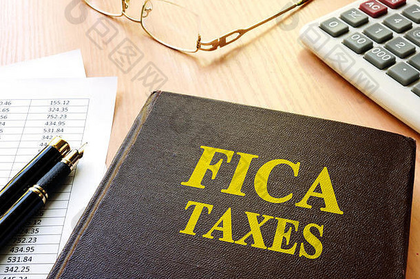 FICA税收和计算器在一张桌子上。