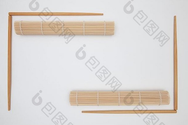 白色桌子上的竹垫和寿司用的筷子。食品设计