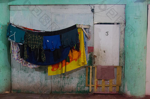 三号公寓的衣服和床单被挂在一栋废墟中晾干。