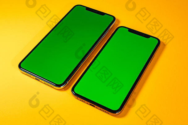 新手机smartphne上的绿度键作为英雄对象出现在明亮迷人的现代霓虹灯流行橙色背景上-智能手机已准备好插入您的应用程序
