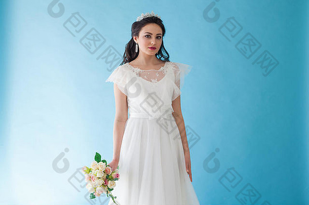 公主新娘身穿白色连衣裙，蓝色底纹上戴着王冠