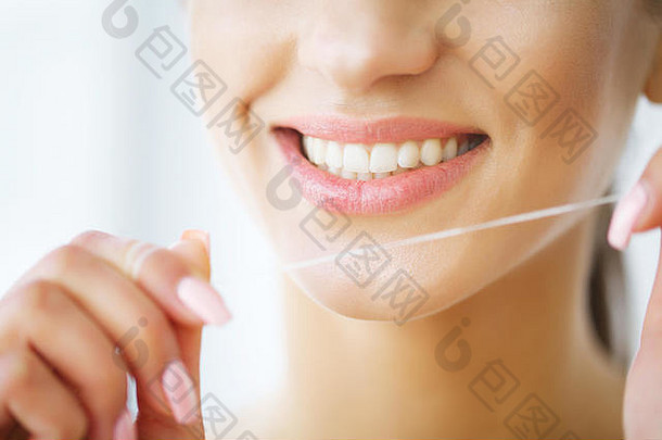 牙齿护理。美丽微笑的女人用牙线洁白健康的牙齿。高分辨率图像