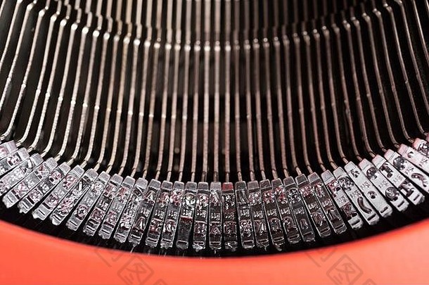 复古式手动打字机的铅条特写或微距镜头，装在铰链式红色顶盖中。