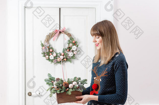 年轻的<strong>女人</strong>持有圣诞节木盒子冷杉分支机构假期一年庆祝活动