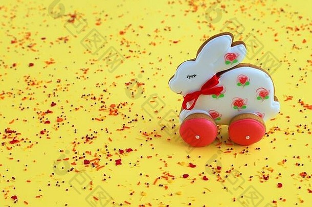 复活节的概念，手工制作的粉红色白色姜饼饼干，黄色背景上的兔子形状。姜饼兔，春天