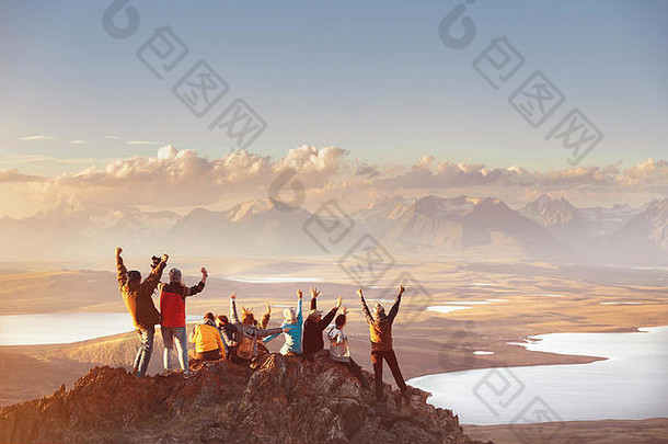 一大群快乐的朋友在山顶上玩，看山谷。冒险还是旅游概念