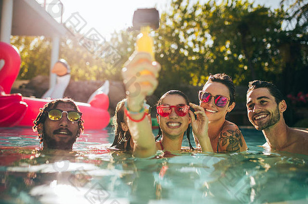 集团快乐年轻的人享受夏天游泳池采取自拍朋友采取自拍游泳池