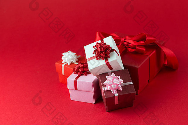 用彩带和红色背景的蝴蝶结包裹的礼品盒