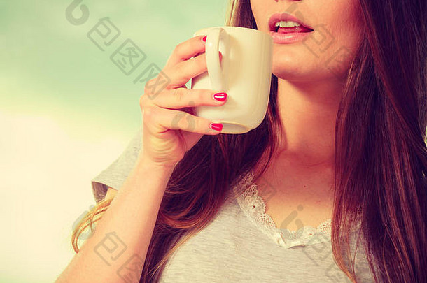 早....喝概念美丽的微笑年轻的女人持有喝杯热咖啡茶室内一半脸