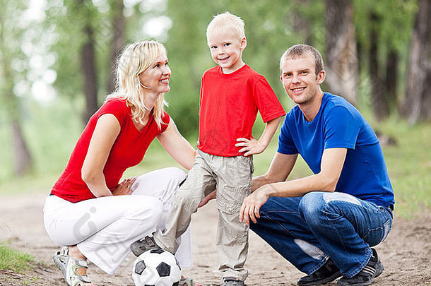 一个快乐的年轻家庭在夏天花时间在户外打球（关注孩子）