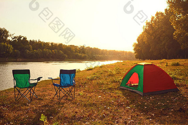 <strong>夏秋</strong>日落时，湖边的帐篷和椅子。
