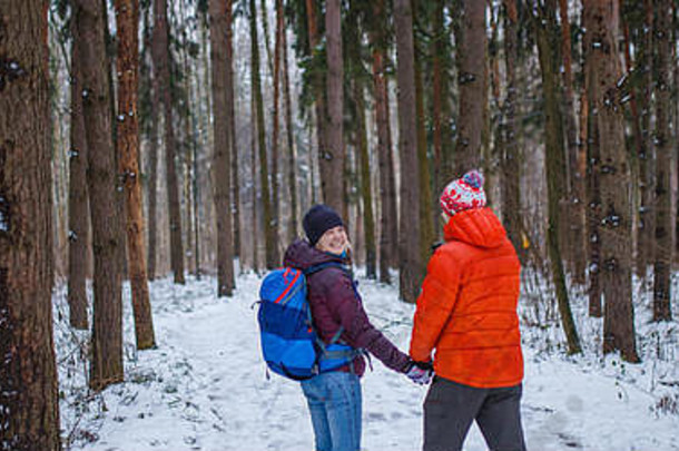 一对男女在冬季森林里散步的照片