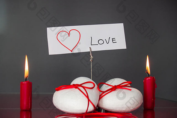 爱的概念点燃了红色蜡烛和心形的烛台，上面写着“我爱你”