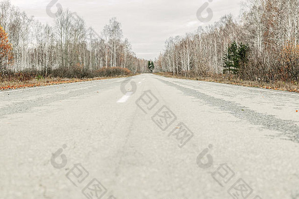 有白色路标的空旷老路。秋天的环境。特写镜头
