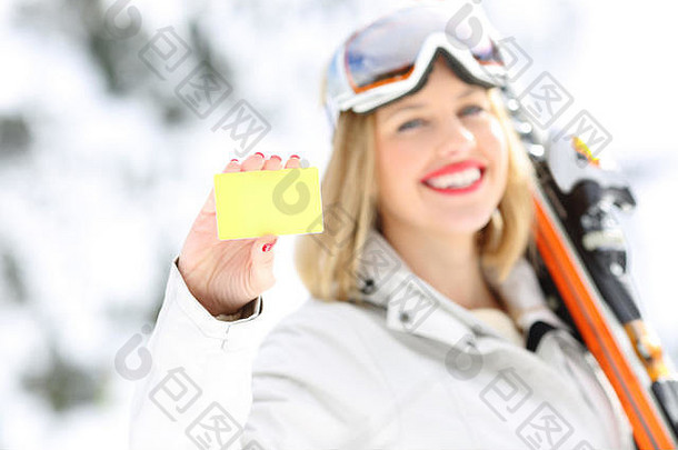 一只快乐的滑雪者手的正视图肖像，背景是一座雪山，背景是斜坡上的一张卡片
