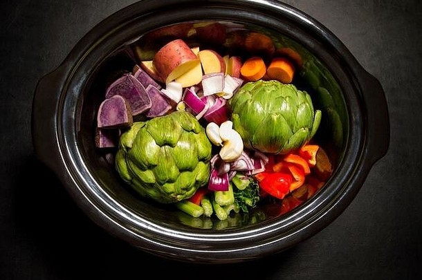 一个大黑锅，上面有切碎的蔬菜，可以随时烹调。慢炖锅、麦田锅。健康观念。