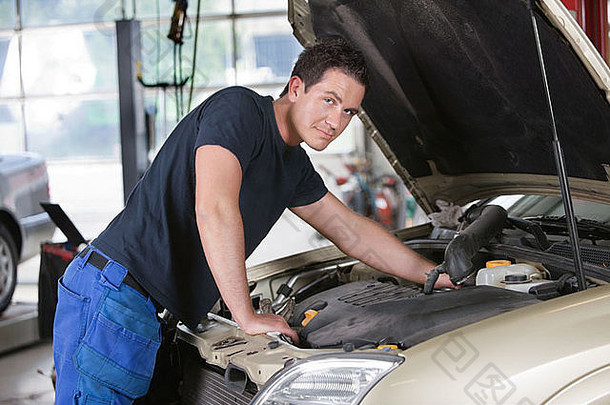 一位在车库里修理汽车的技工的画像
