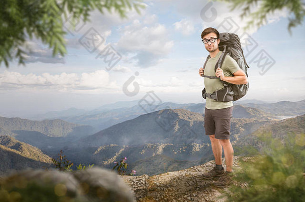 带着一个大背包的徒步旅行者站在热带山脉全景前