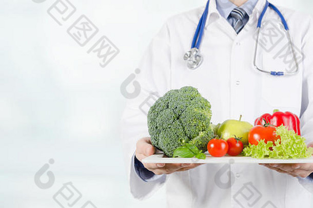 医生把蔬菜和水果放在托盘上。饮食、营养、保健理念。带有空间的网页横幅背景