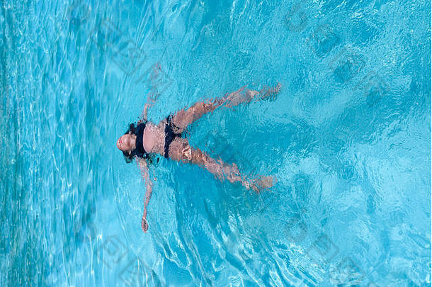 漂亮的运动太阳晒黑女孩浮动游泳池假期美身体护理体育健康健身