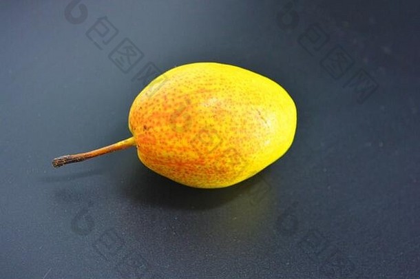 绿色、红色和黄色的鲜美多汁梨位于黑色塑料背景上。适当的营养，健康的新鲜水果。
