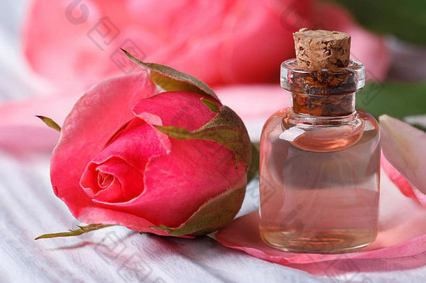 玫瑰水和粉红色美丽的花在一张木桌上