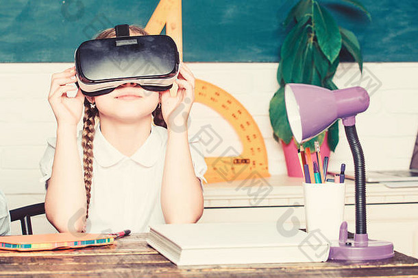 在虚拟现实中学习。现代技术。有趣的一课。虚拟教学。在线家庭教育。女孩在虚拟学校学习。虚拟教育。儿童可爱的小学生戴上头盔虚拟现实眼镜。