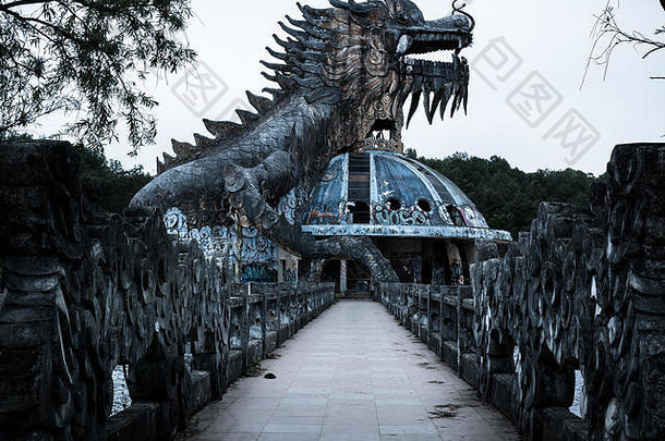 越南顺化苏天湖废弃水上公园的小径剖面图中，巨<strong>大</strong>而可怕的石龙，长着尖刺，张嘴长着牙齿