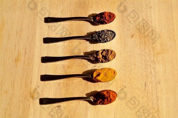 香料架：在木制砧板上摆放有五颜六色的草药香料的小汤匙。