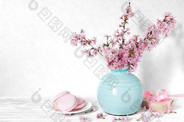 生活花束盛开的樱桃分支机构樱花花瓶礼物盒子蛋白杏仁饼白色表格假期背景
