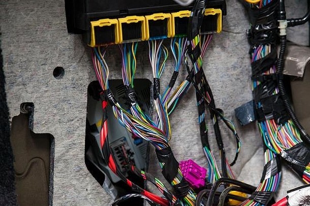 带有多色红色和绿色电线、连接器和接线端子的宽大电缆，用于接线修理车间和电工的连接和传输