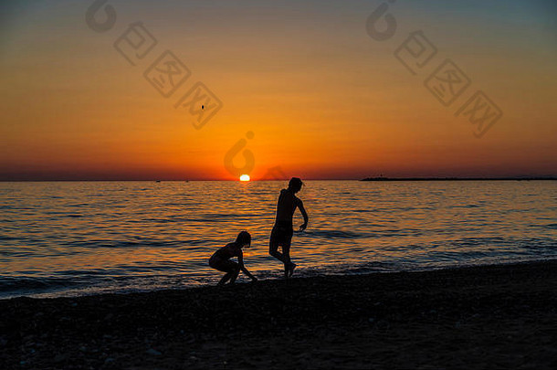 轮廓女孩少年玩扔岩石海海滩日落夏天西西里意大利