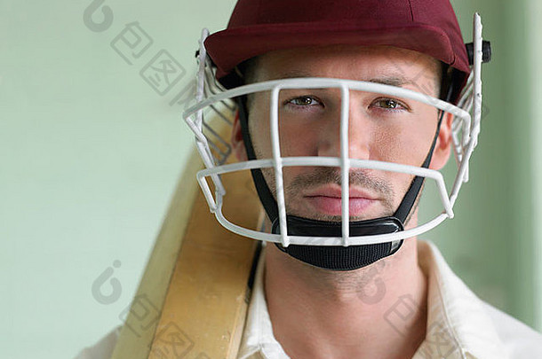 板球运动员戴头盔手持球棒，特写，肖像