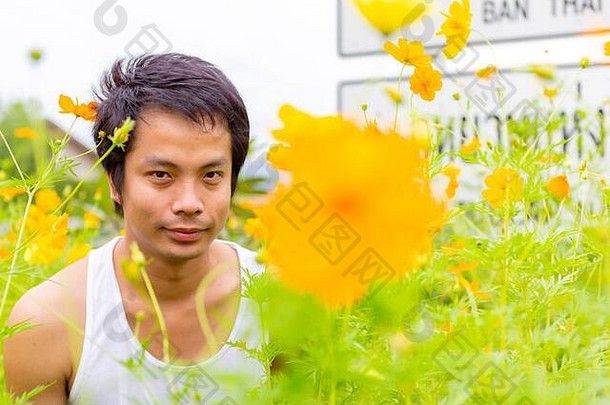 一个穿着白色背心的泰国在黄色的宇宙花园里