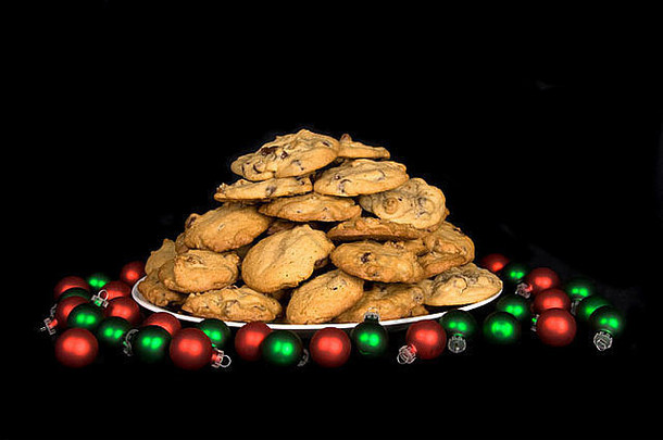 一盘<strong>圣诞</strong>巧克力曲奇饼，四周环绕着黑色的小装饰物