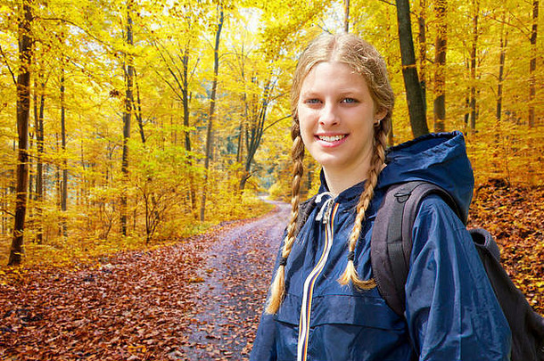 在秋天的森林里徒步旅行的年轻女子