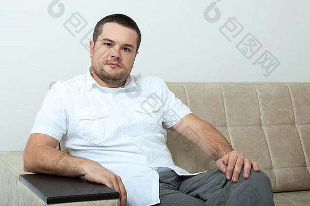 单身中年男子坐在沙发上的肖像
